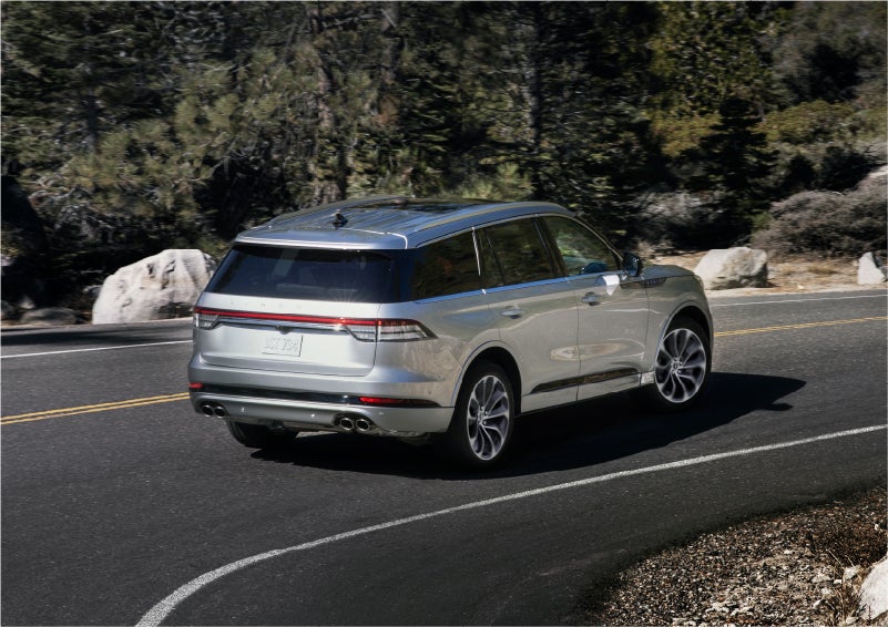A 2023 Lincoln Aviator® Grand Touring model is shown being driven on a tight turn of a mountain road | Gary Yeomans Lincoln in Daytona Beach FL