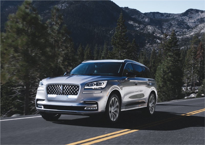 A 2023 Lincoln Aviator® Grand Touring SUV being driven on a winding road to demonstrate the capabilities of all-wheel drive | Gary Yeomans Lincoln in Daytona Beach FL