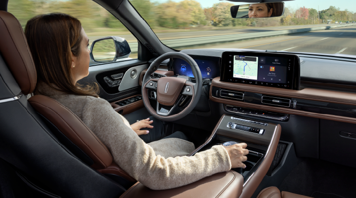 A woman is seen sitting in the driver’s seat of her 2025 Lincoln Aviator® SUV with her hands off the steering wheel. | Gary Yeomans Lincoln in Daytona Beach FL