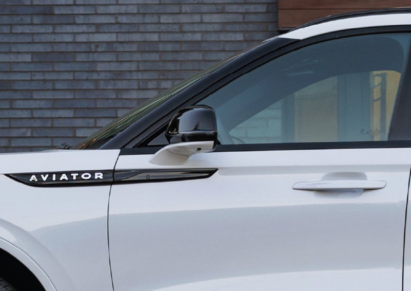 The driver’s side door and fender badging of a white 2026 Lincoln Aviator® SUV are showcased. | Gary Yeomans Lincoln in Daytona Beach FL